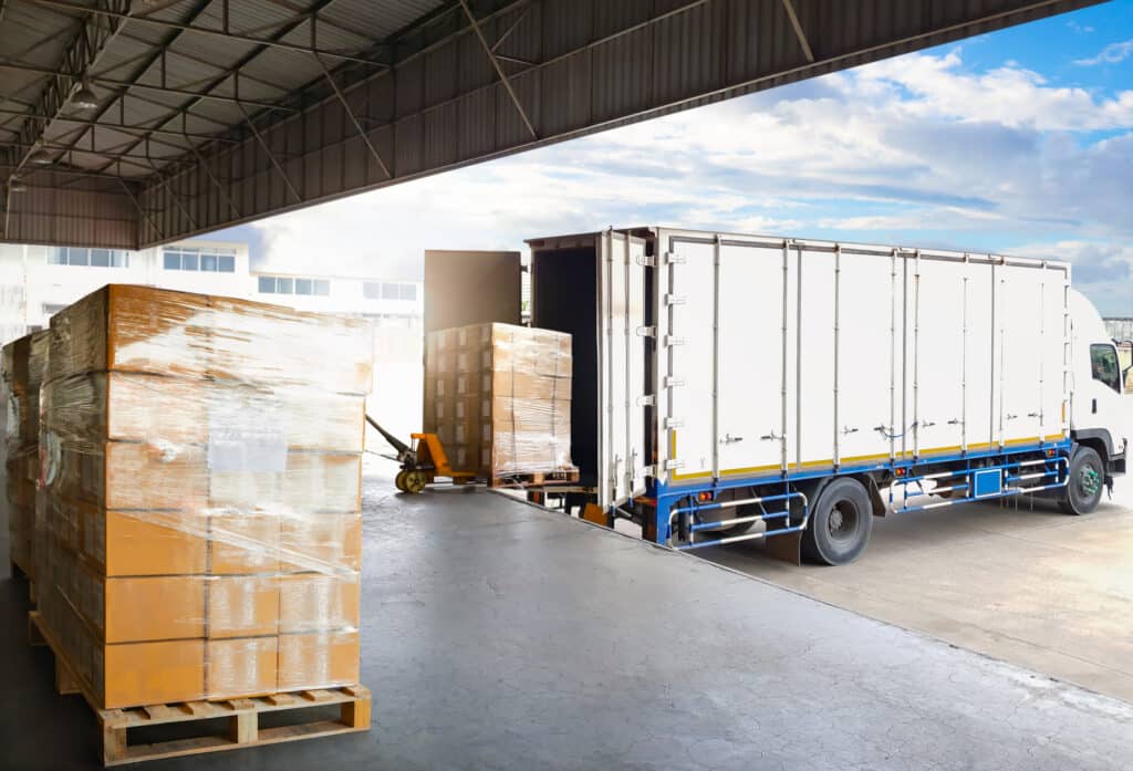 Container Trucks Parked Loading Package Boxes Pallets at Warehouse Dock